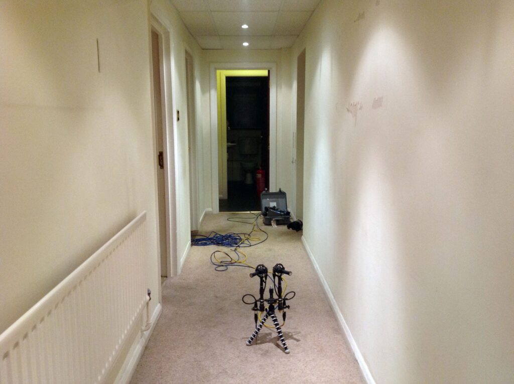 Tripod and cameras set up for sound library field recording in a carpeted hallway—perfect for capturing unique sfx.