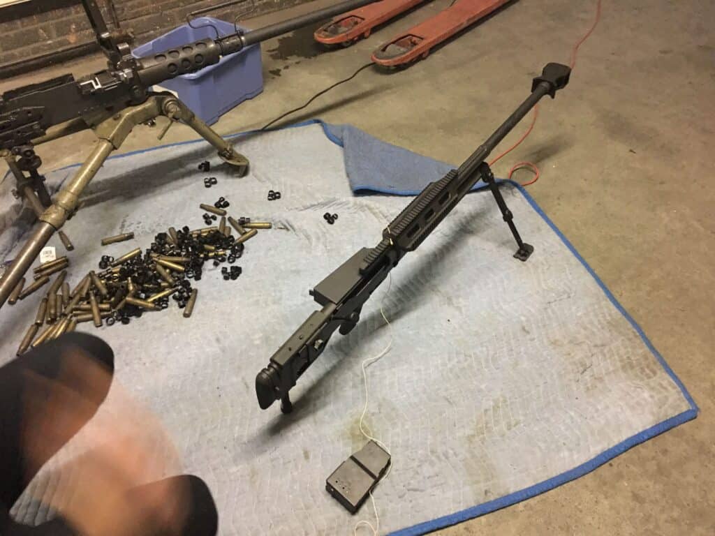 Image of a sound effects library: Large rifle with bipod on blue mat, ammo links—ideal for realistic machine gun sfx capture.