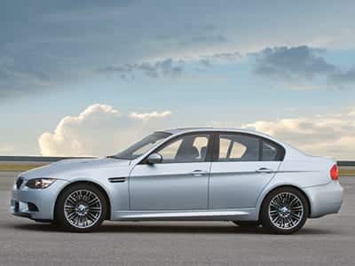 An SFX library image: Silver BMW M3 E92 parked on pavement, perfect for car engine sound effects under cloudy skies.