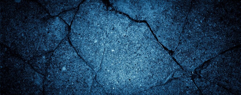 A detailed view of cracked concrete with a blue tintβperfect for urban pavement crack sound effects library inspiration on Sonniss.