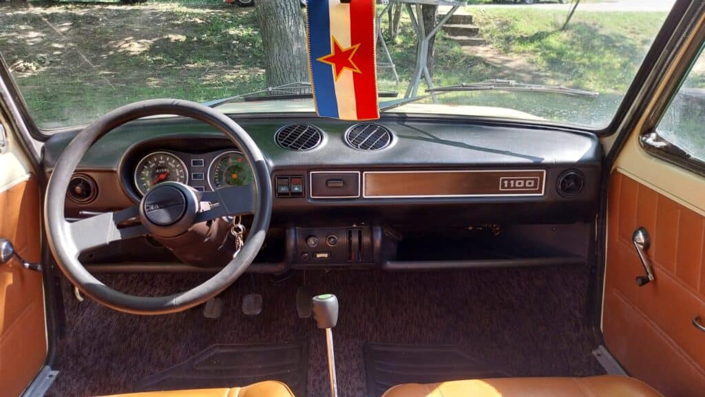 Image of a vintage car sound library on Sonniss: Yugoslavian flag, analog gauges, manual gear stick, leather seats.