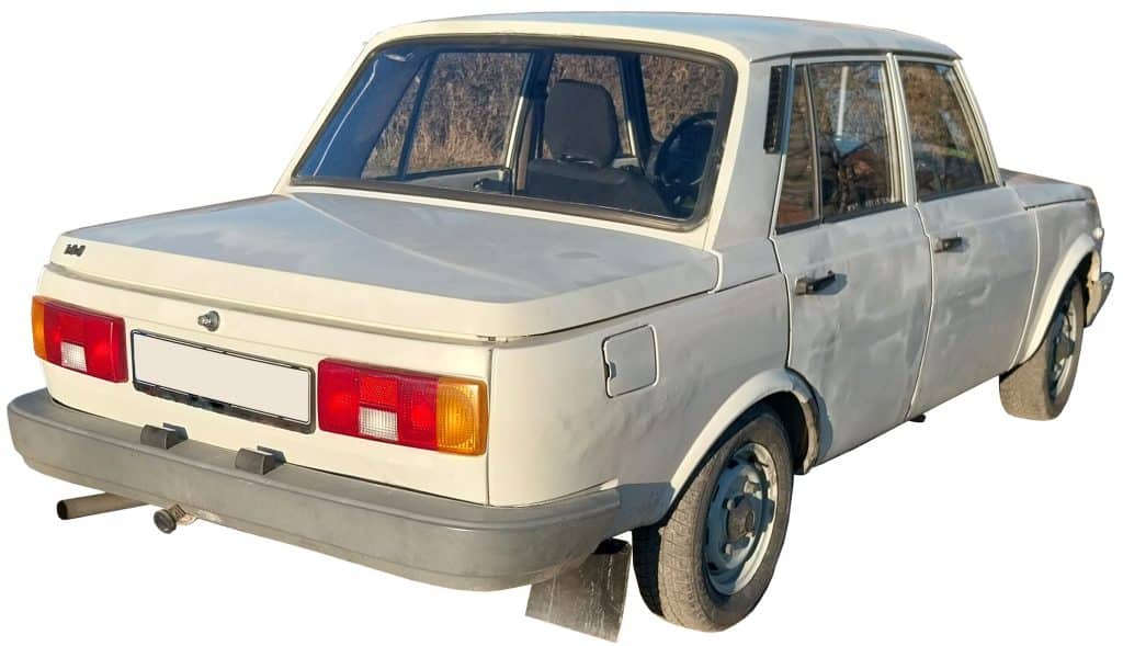 A white four-door sedan with visible wear, rear left view—ideal for car sound effects library images on Sonniss.
