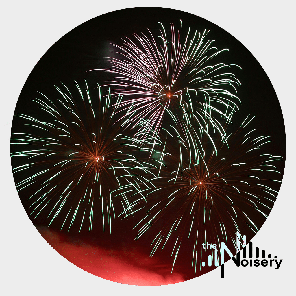 Red and green fireworks light the night sky, showcasing a fireworks sound effects library image for Sonniss by Noisery.