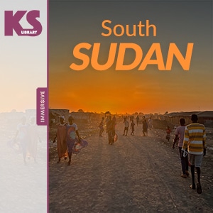 A group of people walking on a dusty road at sunset in South Sudan with an orange sky. Text: "KS Library South Sudan Immersive".