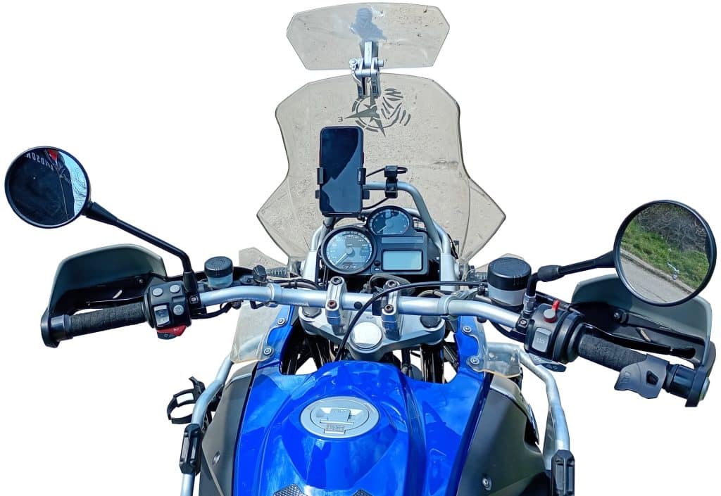 Behind the handlebars of a blue motorcycle with mirrors, throttle, instrument cluster, windscreen, and smartphone holder. Background removed.