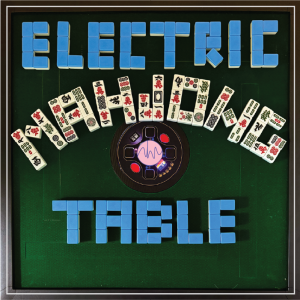 Green mahjong table with blue tiles spelling "ELECTRIC TABLE," assorted mahjong tiles in an arc, and a central area with lights and buttons.