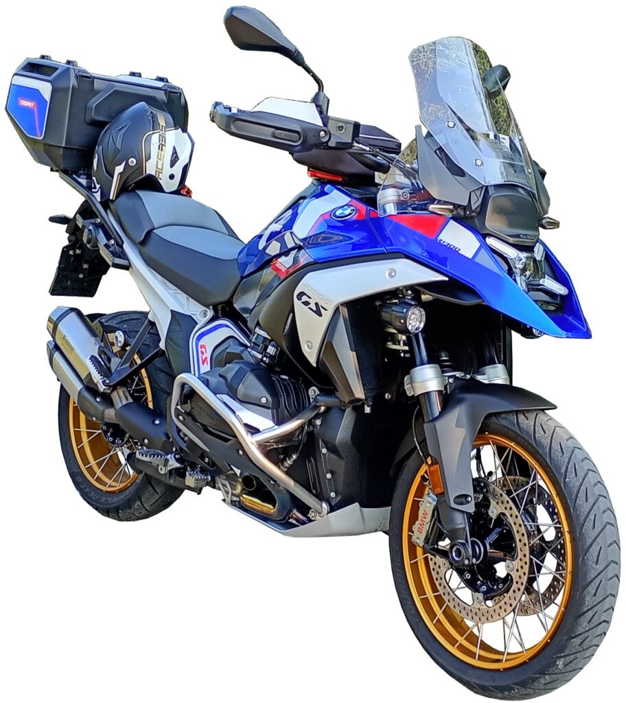 Blue, black, and silver BMW adventure motorcycle with gold wheels and a rear storage box, viewed from a front side angle against a white background.