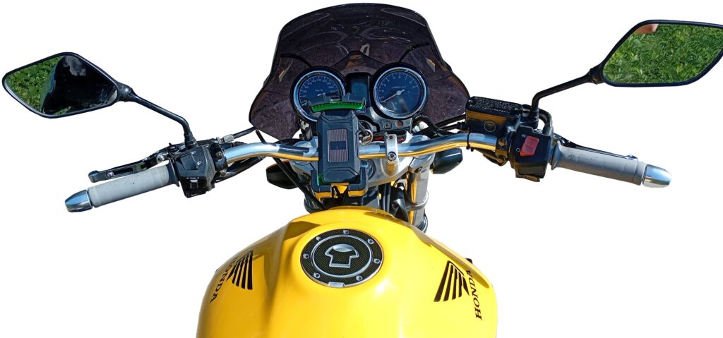 View from the rider’s seat of a yellow motorcycle, with handlebars, side mirrors, speedometer, and a fuel tank featuring the Honda logo, set against a white background.