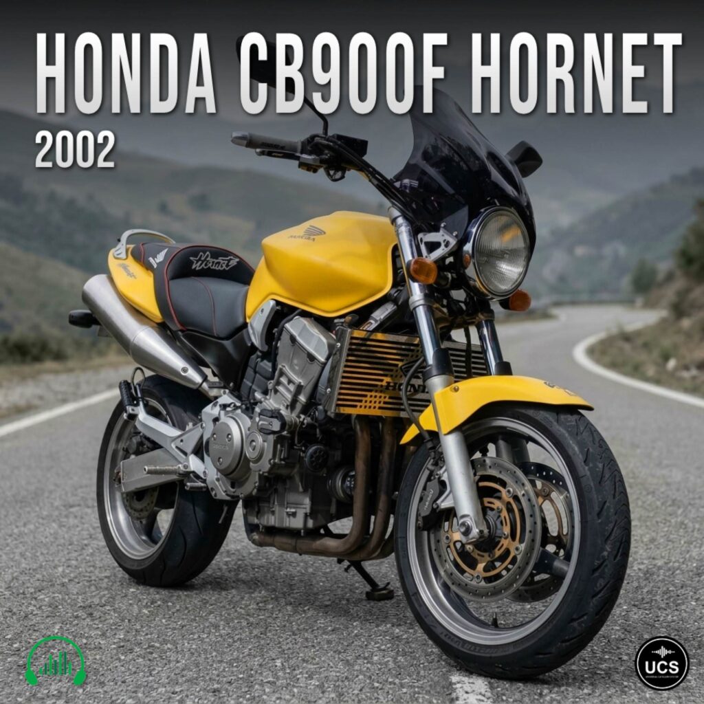 A yellow 2002 Honda CB900F Hornet motorcycle parked on a winding road with hills in the background, angled to show the front and side. Text and logos are visible on the image.
