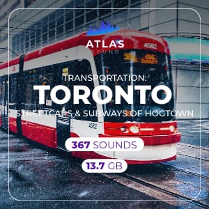 Toronto streetcar in red and white travels along wet city tracks.