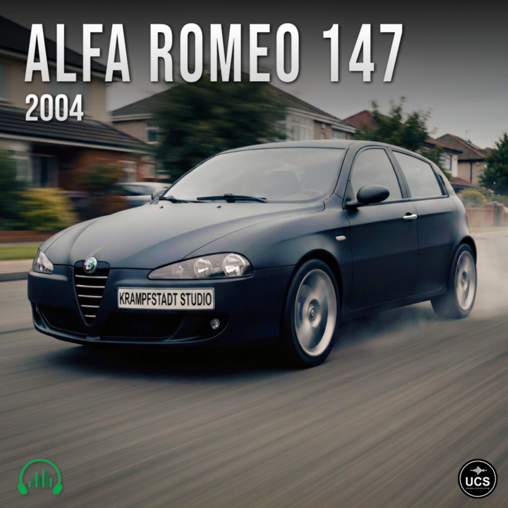 A dark gray 2004 Alfa Romeo 147 compact car drives along a suburban road with visible motion blur.