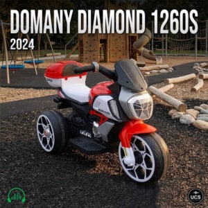 Red and white Domany Diamond 1260S 2024 electric ride-on toy tricycle parked on a playground surface.