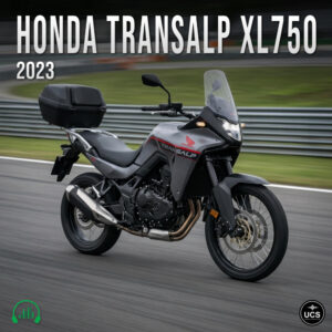 Grey 2023 Honda Transalp XL750 dual sport motorcycle with a rear cargo box rides on a paved racetrack.
