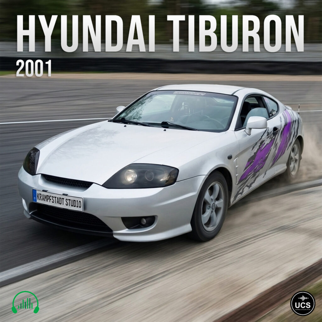 Silver 2001 Hyundai Tiburon sports car with purple graphics drifts fast around a paved track curve.