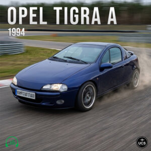 A blue 1994 Opel Tigra A sport compact coupé speeds around a paved race track.