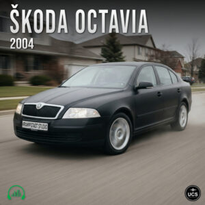 Matte black 2004 Škoda Octavia compact car driving along a suburban street with motion blur.