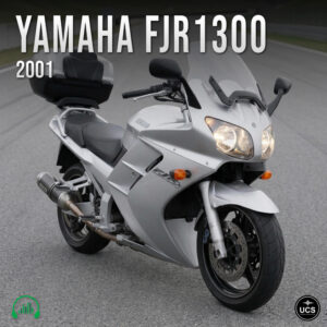Silver 2001 Yamaha FJR1300 sport touring motorcycle with a rear top case parked on a paved track.